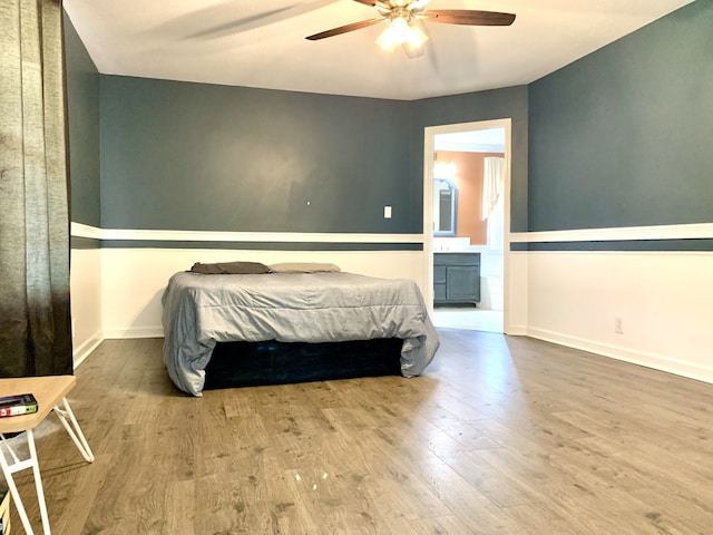 bedroom with connected bathroom, hardwood / wood-style floors, and ceiling fan