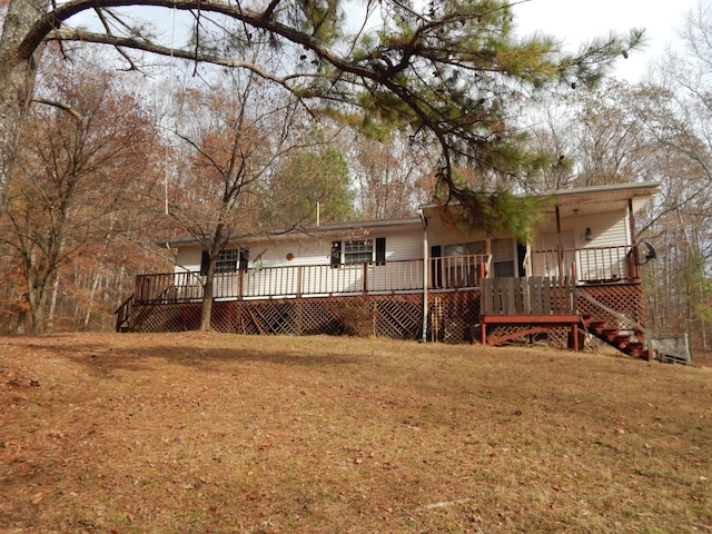 rear view of property with a lawn and a wooden deck