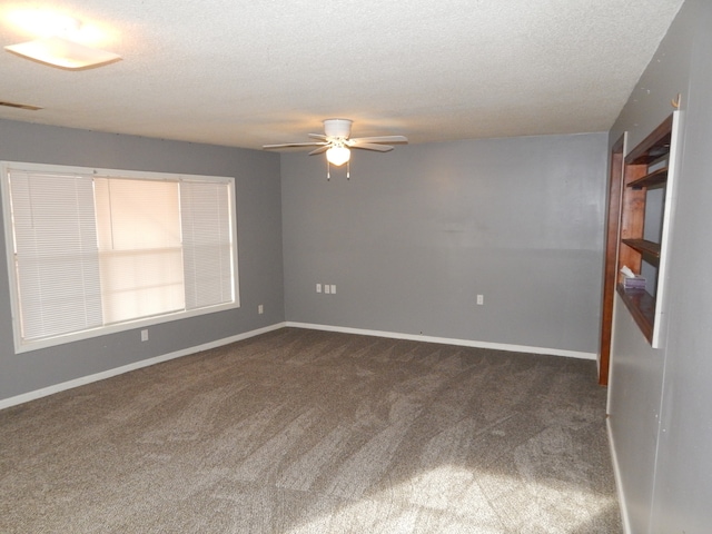 carpeted empty room featuring ceiling fan and a textured ceiling