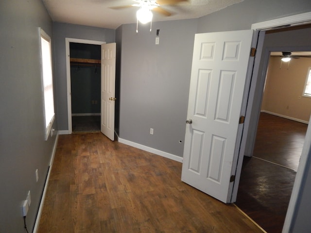 unfurnished bedroom with ceiling fan, dark hardwood / wood-style flooring, a textured ceiling, and a closet