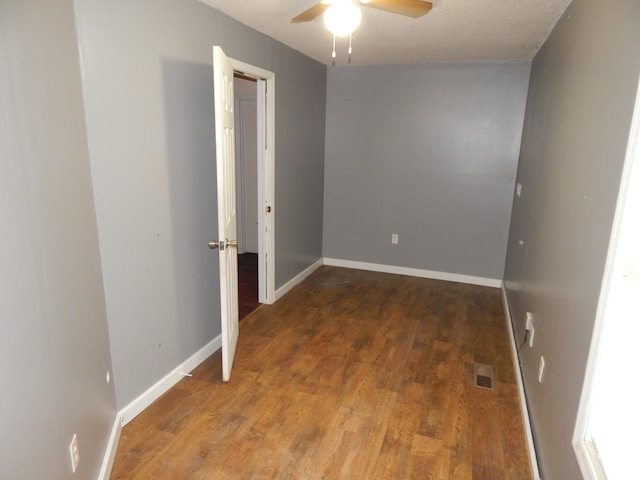 spare room featuring ceiling fan, dark hardwood / wood-style flooring, and a textured ceiling