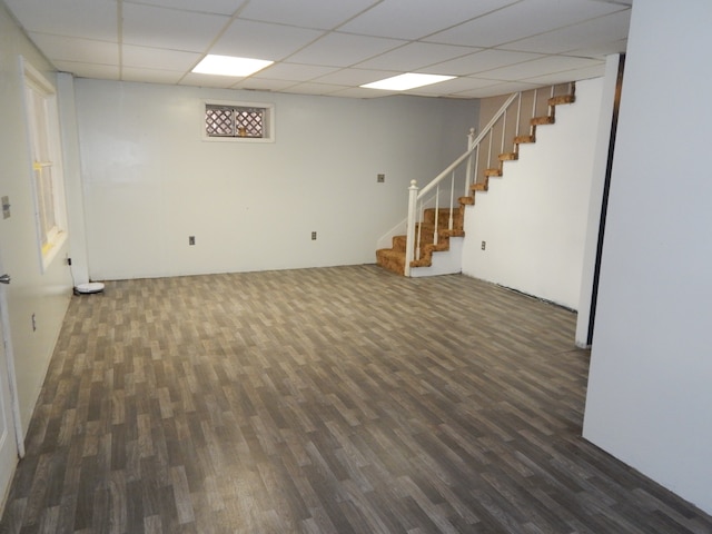 basement featuring a drop ceiling and dark wood-type flooring