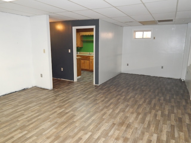 basement with a paneled ceiling and wood-type flooring