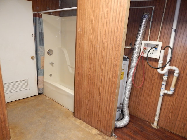 bathroom featuring wood walls, shower / tub combo with curtain, and concrete flooring