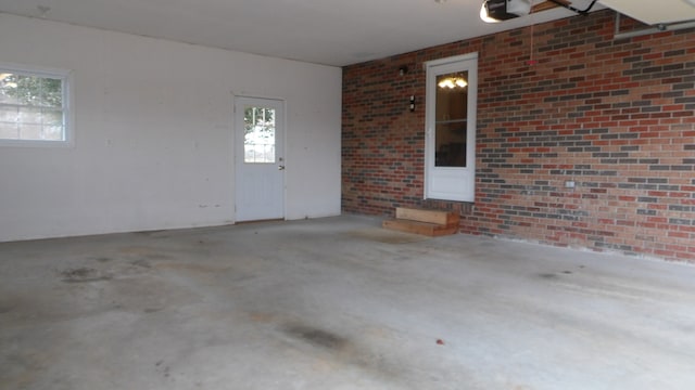 spare room with brick wall and concrete floors