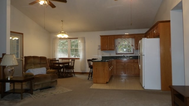 kitchen featuring light colored carpet, white fridge, high vaulted ceiling, decorative light fixtures, and ceiling fan with notable chandelier