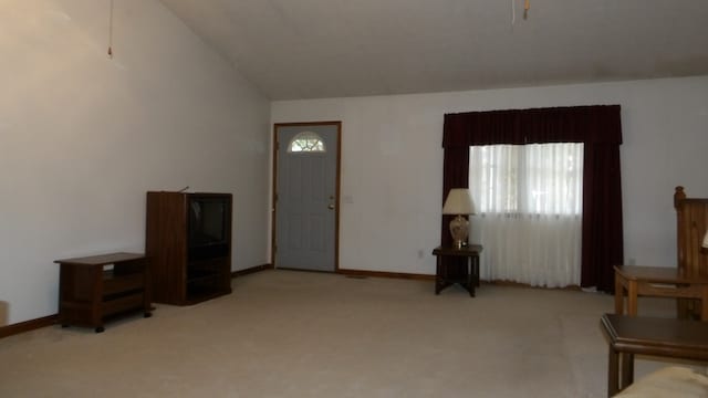 foyer featuring light colored carpet and vaulted ceiling