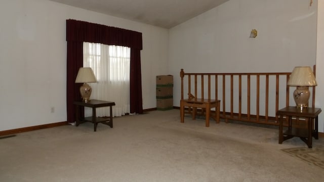 sitting room with lofted ceiling and light colored carpet