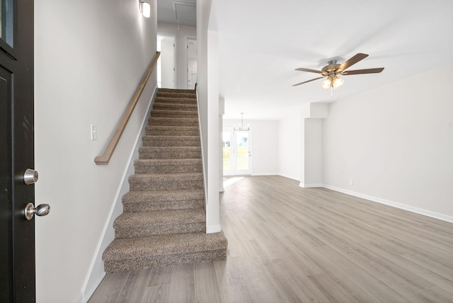 stairway with ceiling fan and hardwood / wood-style flooring