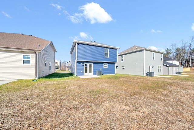 rear view of house featuring a lawn, french doors, and cooling unit