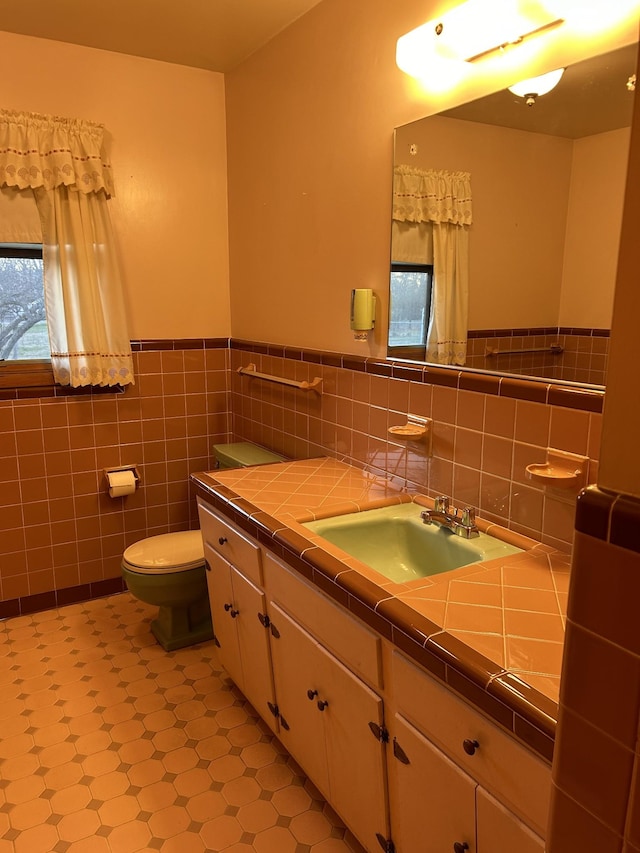 bathroom featuring vanity, tile walls, and toilet