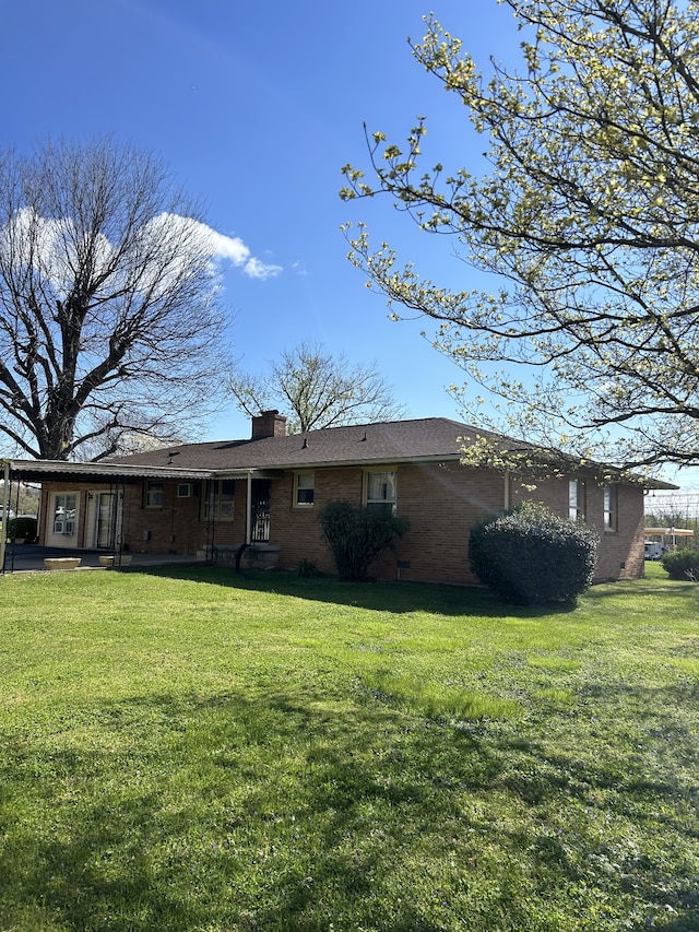 rear view of property featuring a lawn