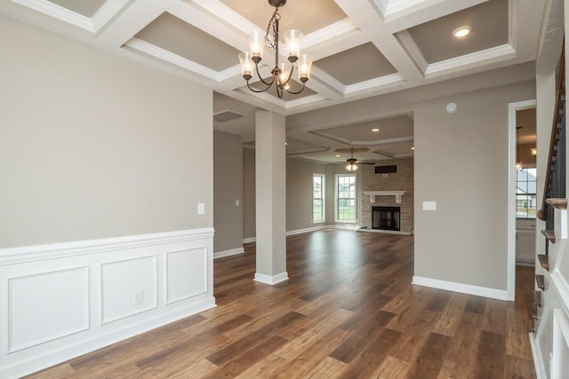 unfurnished dining area featuring ornamental molding, dark wood-type flooring, and a brick fireplace