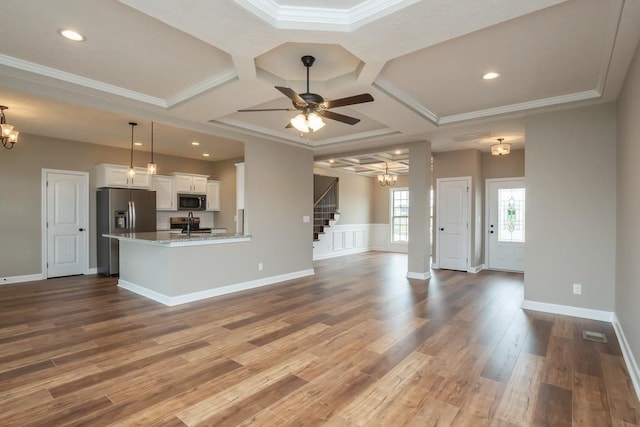 unfurnished living room with hardwood / wood-style floors, ceiling fan with notable chandelier, crown molding, and coffered ceiling