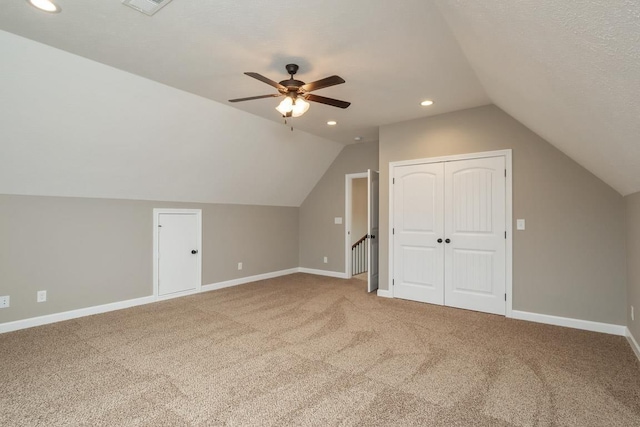 additional living space featuring a textured ceiling, ceiling fan, carpet floors, and lofted ceiling