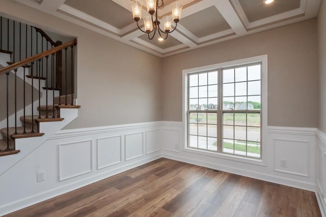 interior space featuring coffered ceiling, an inviting chandelier, beamed ceiling, hardwood / wood-style floors, and ornamental molding