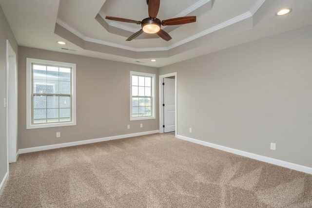 spare room featuring carpet flooring, a tray ceiling, ceiling fan, and crown molding