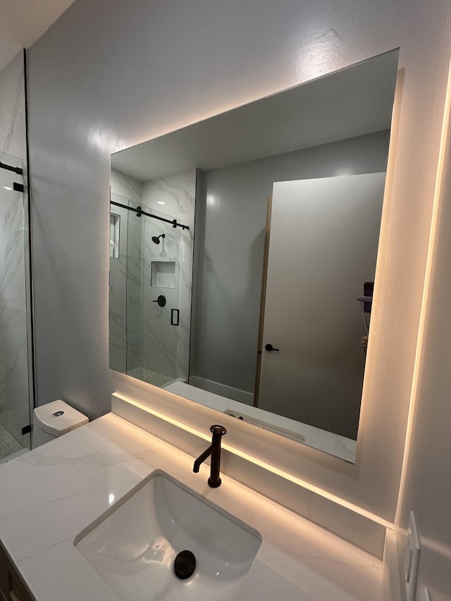 bathroom with walk in shower, vanity, and toilet