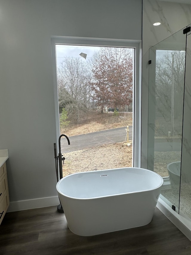 bathroom featuring vanity, hardwood / wood-style floors, and a tub