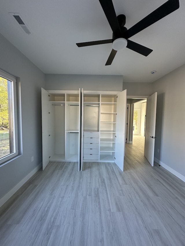 unfurnished bedroom featuring two closets, light hardwood / wood-style flooring, and ceiling fan