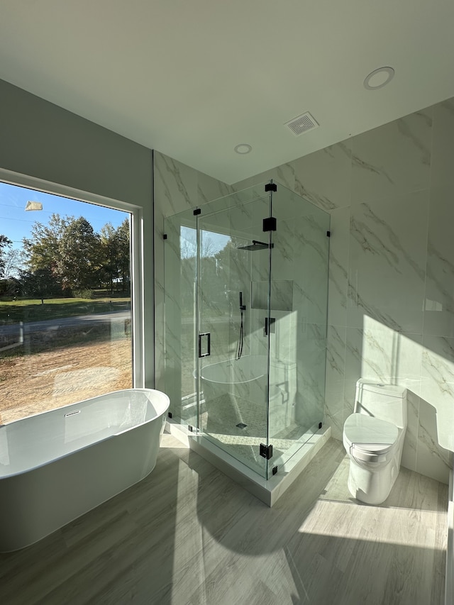 bathroom featuring independent shower and bath and toilet