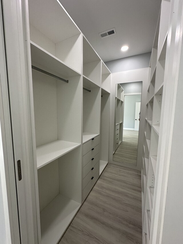 spacious closet with light hardwood / wood-style flooring