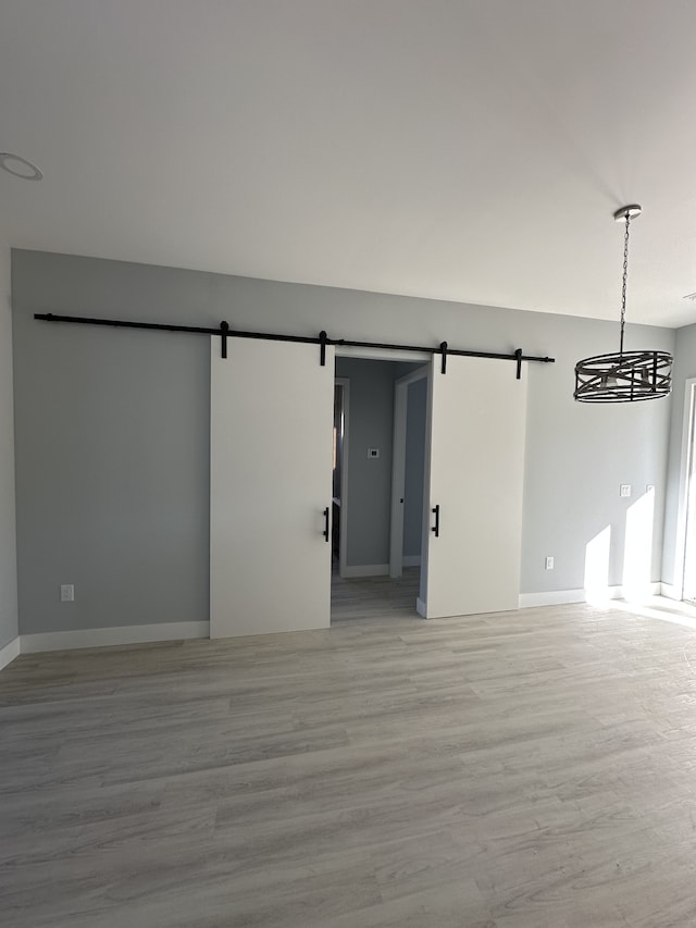 spare room featuring light hardwood / wood-style floors and a barn door