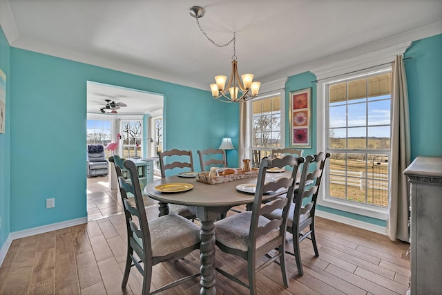 dining area featuring wood-type flooring, ceiling fan with notable chandelier, and crown molding