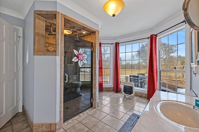 bathroom with tile patterned flooring, vanity, ornamental molding, a shower with shower door, and toilet