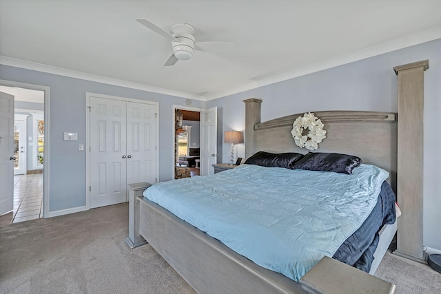 bedroom with crown molding, light carpet, ceiling fan, and a closet