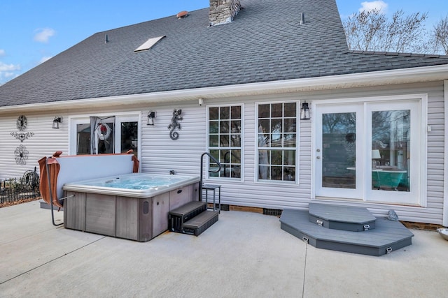 rear view of property featuring a patio area and a hot tub