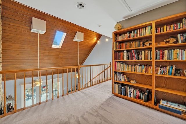 corridor featuring vaulted ceiling with skylight and carpet