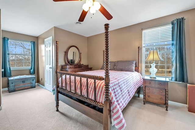 carpeted bedroom featuring multiple windows and ceiling fan