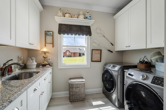 laundry area with cabinets, separate washer and dryer, and sink