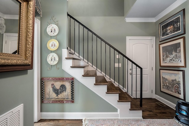 staircase with hardwood / wood-style flooring and ornamental molding