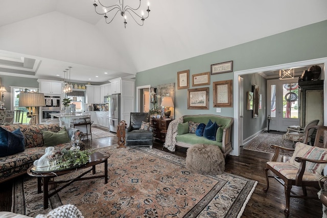 living room with dark wood-type flooring, high vaulted ceiling, and a chandelier