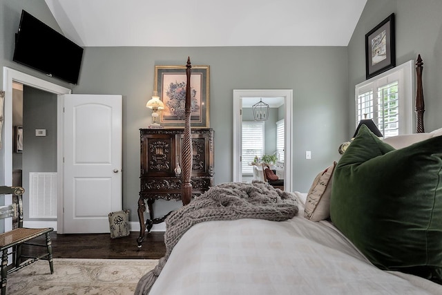 bedroom with wood-type flooring and vaulted ceiling