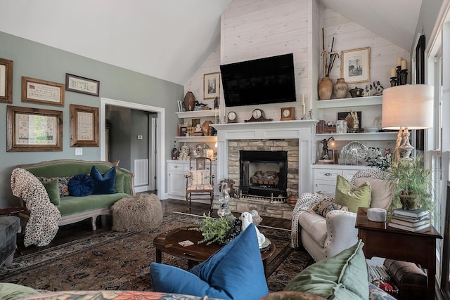 living room featuring lofted ceiling and a stone fireplace