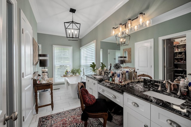 bathroom featuring tile patterned floors, crown molding, a chandelier, vanity, and a bathing tub