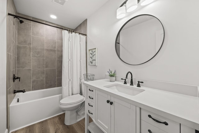 full bathroom with hardwood / wood-style flooring, shower / bath combo, toilet, and vanity