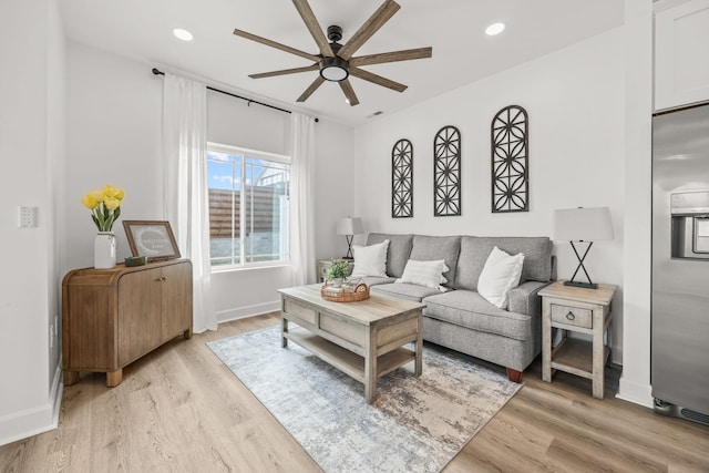 living room featuring light hardwood / wood-style flooring and ceiling fan