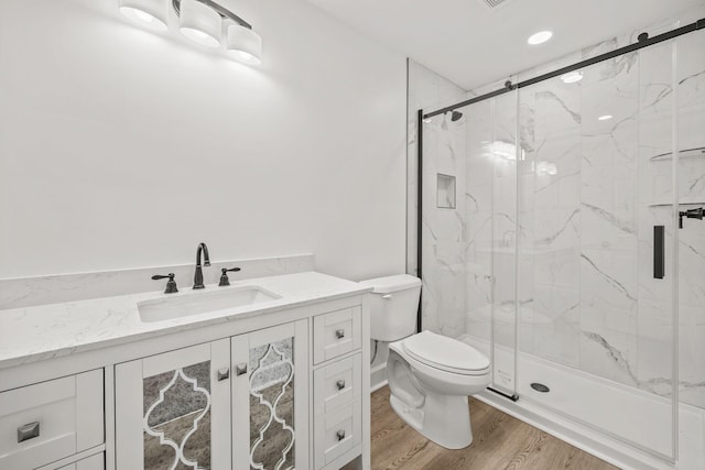 bathroom with walk in shower, toilet, vanity, and hardwood / wood-style flooring