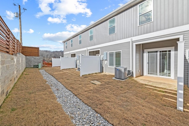 rear view of property featuring a yard and cooling unit