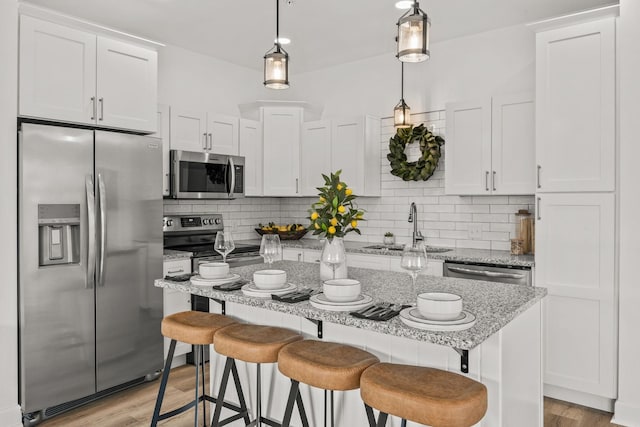 kitchen featuring pendant lighting, white cabinets, sink, and appliances with stainless steel finishes