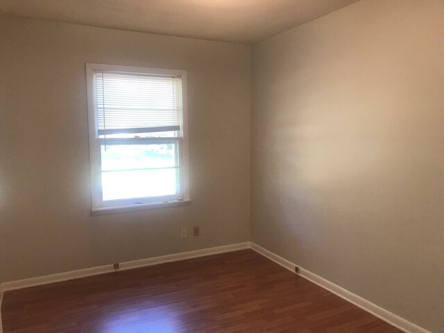 unfurnished room with dark hardwood / wood-style floors