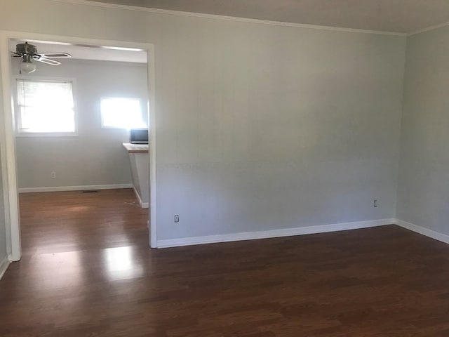 empty room with ceiling fan, ornamental molding, and dark wood-type flooring