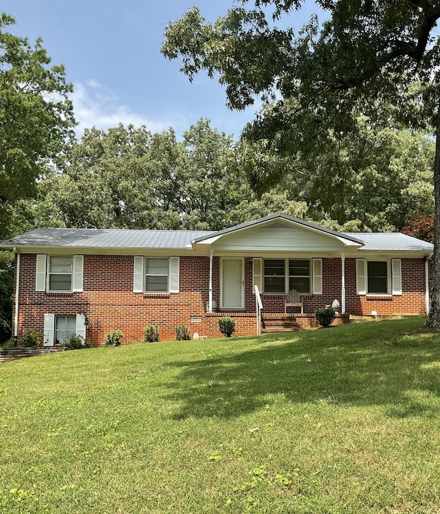 ranch-style home with covered porch and a front yard