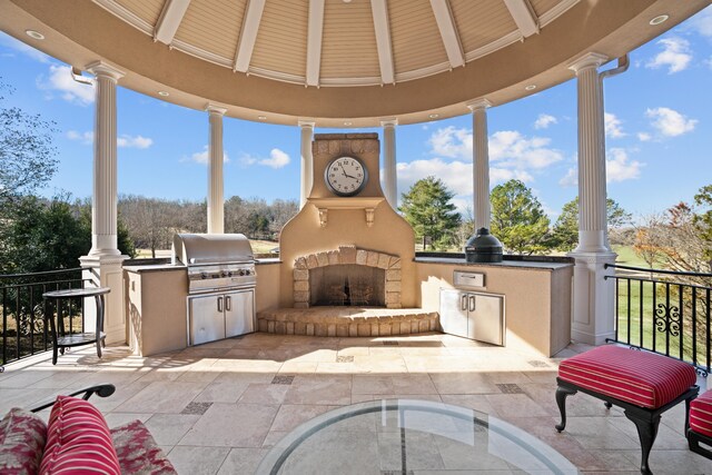 view of patio with a large fireplace, a gazebo, and area for grilling