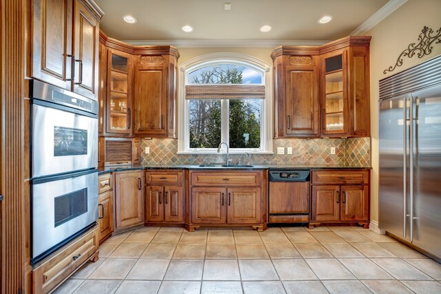 kitchen featuring appliances with stainless steel finishes, a sink, and brown cabinets