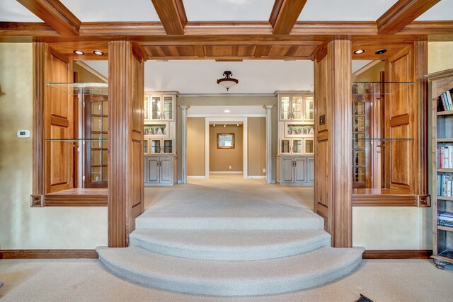 hallway featuring ornamental molding, coffered ceiling, carpet flooring, and beam ceiling